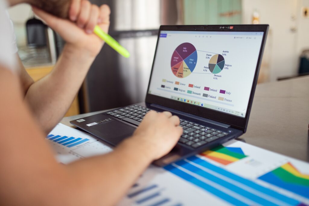 De frente para um laptop, uma pessoa lê os dados advindos de gráficos de métricas de marketing digital expostos na tela.